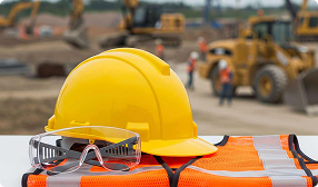 Hard hat sitting on a table with a construction site in the background